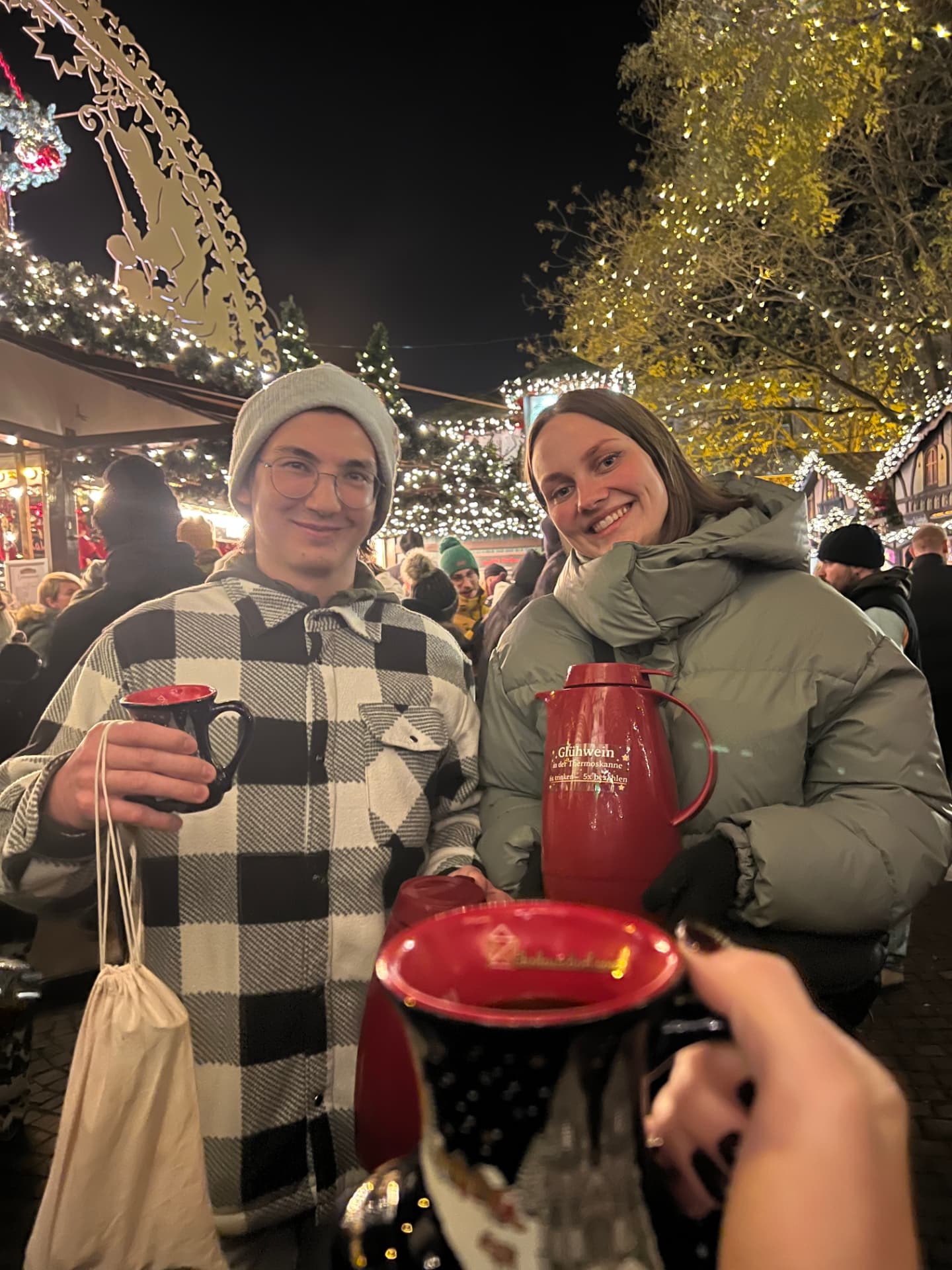 Zwei Teammitglieder mit Glühwein auf dem Weihnachtsmarkt