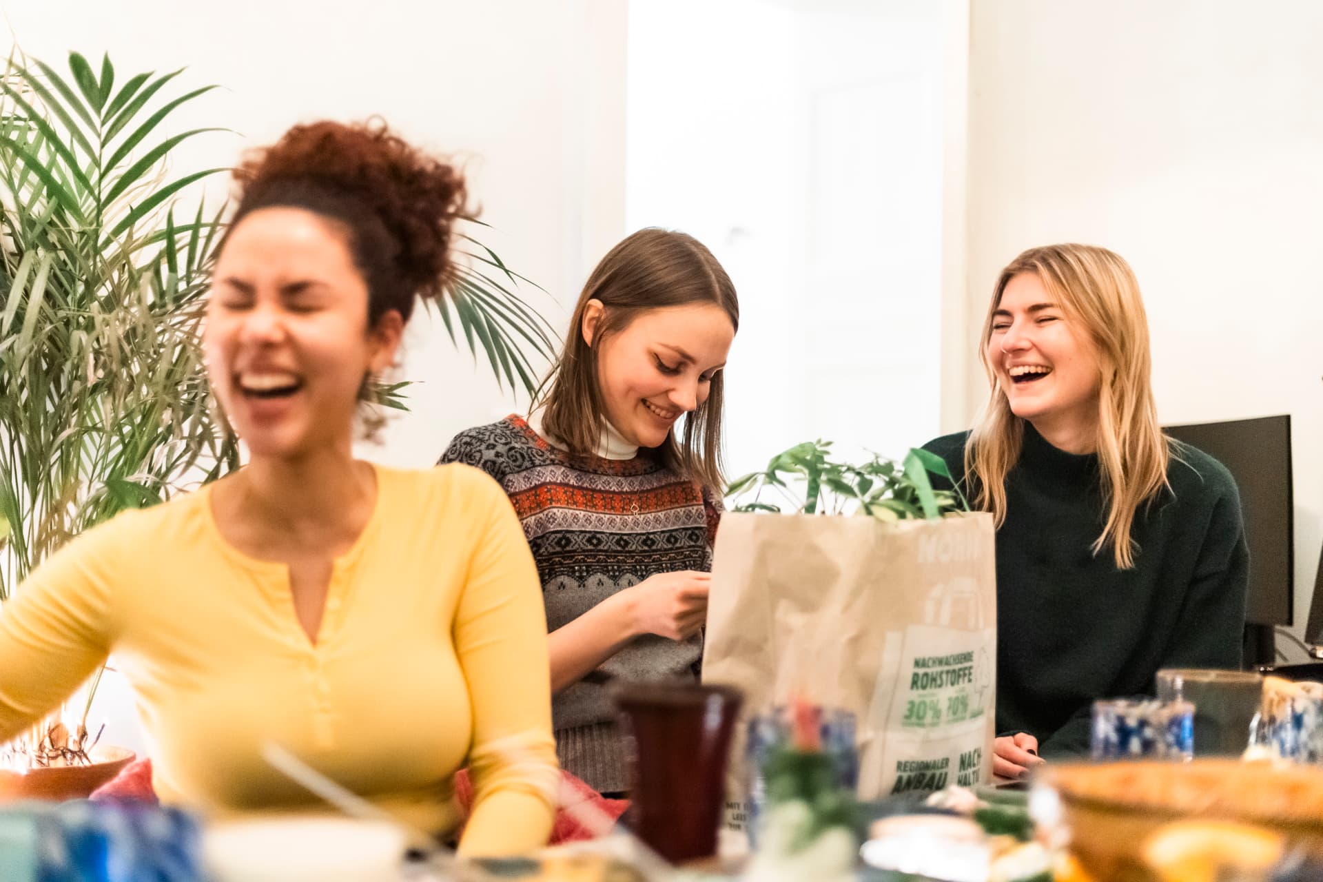 Teammitglieder lachen beim Wichteln im Office