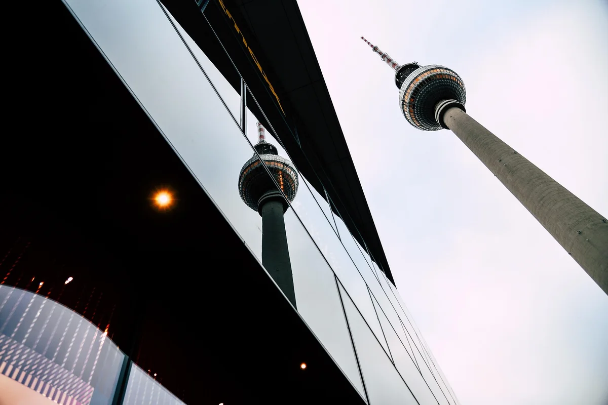 Berliner Fernsehturm, der sich in einer Glasfassade spiegelt